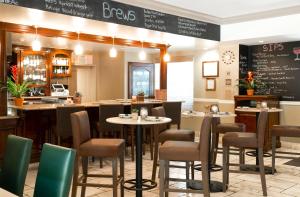 um restaurante com mesas e cadeiras e um bar em Ayres Hotel & Spa Mission Viejo - Lake Forest em Mission Viejo