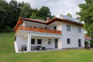 a white house with solar panels on the roof at Lake View Apartments in Keutschach am See