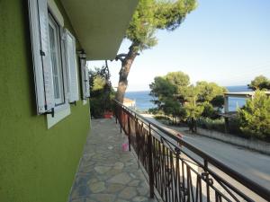 a green building with a balcony with a view of the ocean at Yialos apartments in Kefallonia