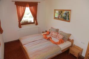 a bedroom with a bed with an orange ribbon on it at APARTMA KOŠNIK in Bohinj