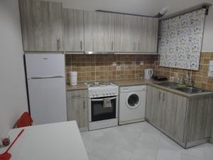 a kitchen with a white refrigerator and a dishwasher at Yialos apartments in Kefallonia