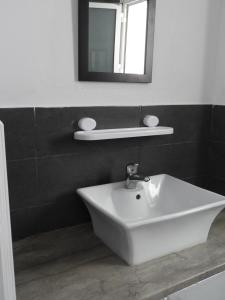 y baño con lavabo blanco y espejo. en Appartement quartier Dar Sebastian, Hammamet en Hammamet