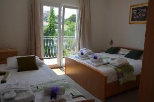 two beds in a hotel room with towels on them at Apartment A. Žižić in Slatine