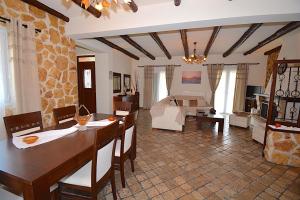 a living room with a table and a room with a bed at Villa Alex in Sinarádes