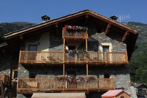 ein Haus mit einem Balkon mit Blumen darauf in der Unterkunft Maison Chenal in Montjovet