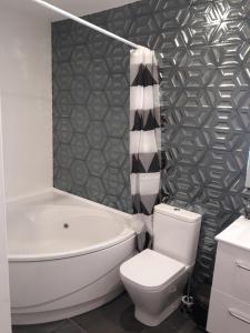 a bathroom with a white toilet and a tub and a sink at Islabeach in Isla