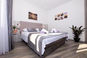 a bedroom with a large bed with white sheets at Apartmani Split L&A in Split