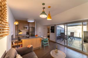 cocina y sala de estar con sofá y mesa en Living Las Canteras Homes - BEACHFRONT ROOFTOP, en Las Palmas de Gran Canaria