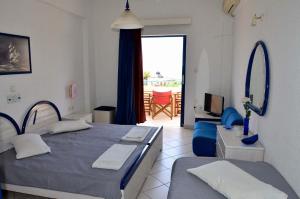 a bedroom with a bed and a living room at Anna Studios in Agia Marina Aegina