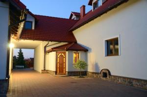 a white house with a brown roof at Za Stodołą in Wydminy