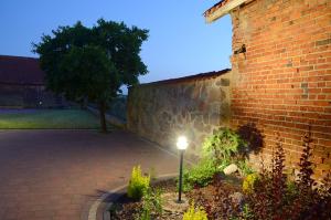 a light in a garden next to a brick building at Za Stodołą in Wydminy