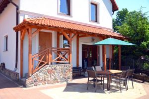 a patio with an umbrella and a table and chairs at Za Stodołą in Wydminy