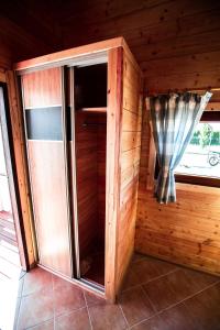 - un sauna en bois avec une fenêtre et un rideau dans l'établissement Domki Heaven Ustronie Morskie, à Ustronie Morskie