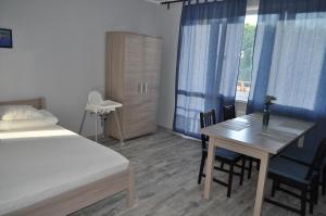 sypialnia z łóżkiem, stołem i krzesłami w obiekcie Apartament Wrzos w Dziwnówku