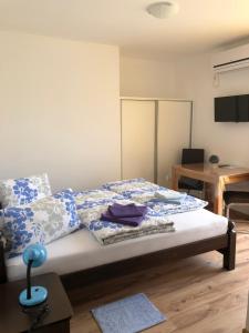 a bedroom with a bed with blue and white pillows at Apartment & Rooms Thomas in Korenica