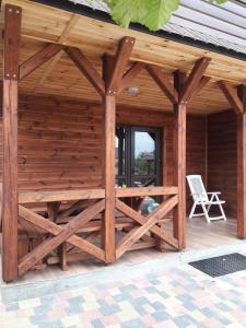 a wooden pavilion with a chair on a patio at Шале Озера in Melʼniki +4 photos