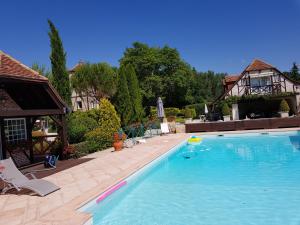 a large swimming pool in a yard with a house at Moulin du soustre in Cavagnac