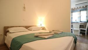 sypialnia z 2 łóżkami i ręcznikami w obiekcie Laganini Apartments w Splicie