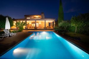 a swimming pool in front of a house at night at Villa Marín Toledo in Las Nieves