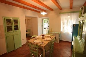 a dining room with a table and a kitchen at Holiday Home Krista in Miholašćica