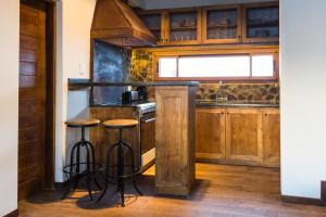 a kitchen with wooden cabinets and bar stools at Villa Montaña in Las Lenas