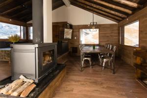 a living room with a fireplace and a table at Villa Montaña in Las Lenas