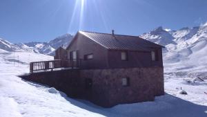a brick house in the snow with mountains in the background at Villa Montaña in Las Lenas +12 photos