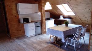 a kitchen and dining room with a table in a cabin at Apartamenty Pod Lipami in Junoszyno