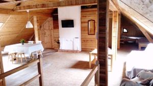 a dining room with a table and a tv in a building at Apartamenty Pod Lipami in Junoszyno