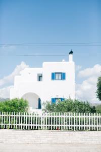 a white house behind a white picket fence at Ktima Tzaneti in Lachania