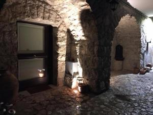 Camera scavata nella roccia con TV in un muro di pietra di Casa Sarlo a Petina