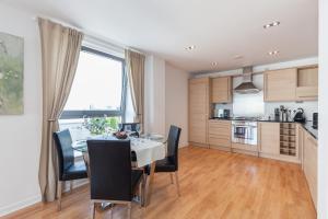 a kitchen and dining room with a table and chairs at Stylish Garden View Apartment in Edinburgh
