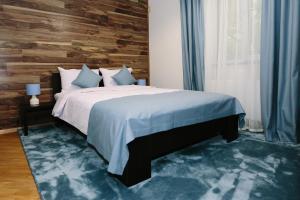 1 dormitorio con 1 cama y pared de madera en Sunny Hotel en Leópolis
