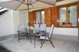 - une table et des chaises avec un parasol sur la terrasse dans l'établissement La terraza del Sauce, à Jaca