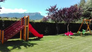 een speeltuin met een glijbaan en een schommel bij La terraza del Sauce in Jaca