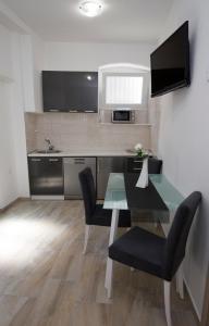 a kitchen with a table and chairs and a television at Old Town Apartment Split in Split