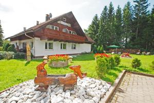 a house with a statue in front of a yard at Gästehaus Tannenhof in Clausthal-Zellerfeld