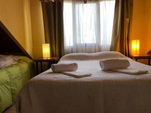 1 dormitorio con 2 toallas en una cama con ventana en cabanas las moras en El Bolsón