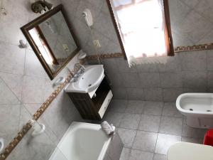 y baño con lavabo, aseo y espejo. en cabanas las moras en El Bolsón