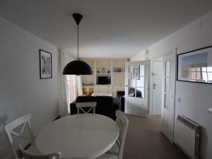 Apartamento Maraka Playa Castelldefels في كاستيلديفِيلس: طاولة بيضاء وكراسي في غرفة المعيشة