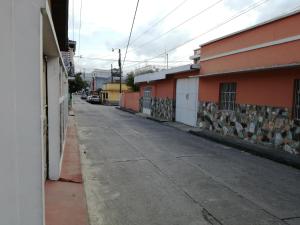 an empty street in a town with orange buildings at Hotel Bethel in Cobán