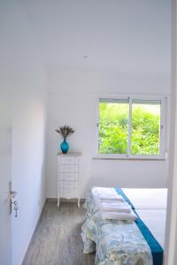 a white bedroom with a bed and a window at Belém River Apartment II in Lisbon