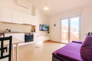 a kitchen and living room with a table and a couch at Sunset View Apartment in Zadar