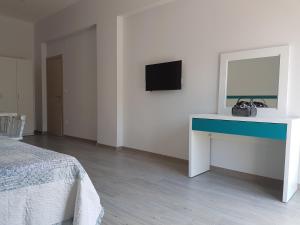 a bedroom with a desk and a tv on a wall at Apartments and Rooms Lijesevic in Budva