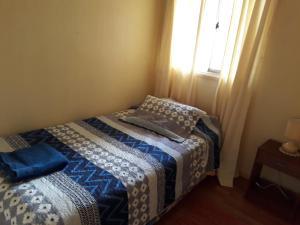 a small bedroom with a bed and a window at Casa Jardines del Mar, Puerto Montt in Puerto Montt