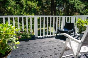 une chaise assise sur une terrasse en bois à côté d'une clôture dans l'établissement Fisher House, à Sopot