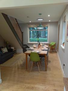 a dining room with a table and green chairs at Lowood Cottage in Edinburgh