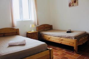 a bedroom with two beds and a window at A FATA DI L'ORTOLO gîtes à la ferme in Sartène