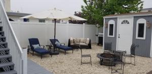 a patio with chairs and an umbrella and a shed at 1st floor cottage! One Block to Beach, Convention Center and Wildwood Crest! in Wildwood