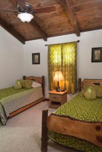 a bedroom with two beds and a ceiling fan at The Dogwood Breeze in Aquone
